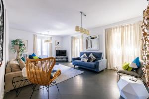 Amazing flat 5 balconies in Chueca - Gran Via في مدريد: غرفة معيشة مع أريكة وكرسي