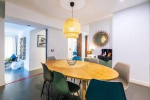 a dining room with a wooden table and chairs at Amazing flat 5 balconies in Chueca - Gran Via in Madrid