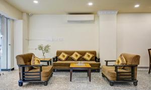 uma sala de estar com um sofá e duas cadeiras em Treebo Trend Jheel Mahal em Udaipur