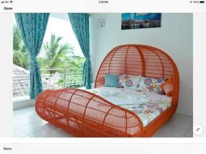 ein orangefarbenes Bett in einem Zimmer mit Fenster in der Unterkunft RRJ's BEACH RESORT in Oslob