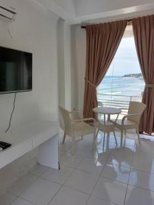 a living room with a table and chairs and a television at RRJ's BEACH RESORT in Oslob