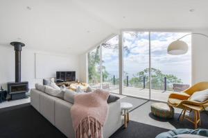 a living room with a couch and a large window at Nest over the Bay. Amazing views! in Arthurs Seat