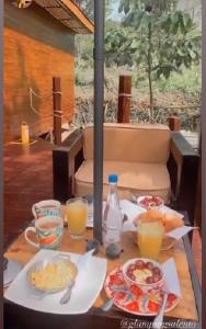 薩蘭托的住宿－Glamping Salento con jacuzzi climatizado，餐桌上放有食物和橙汁