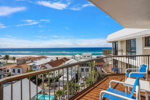 a balcony with chairs and a view of the ocean at Beach Palms Holiday Apartments in Gold Coast