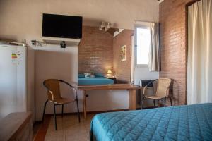 a bedroom with a bed and a table and chairs at Complejo Las Hoyas in Villa Carlos Paz