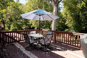 een tafel en stoelen onder een paraplu op een terras bij Yellow Brick Home in Jefferson City