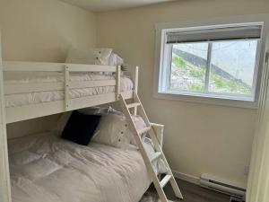 a bedroom with a bunk bed and a window at Bearcub Chalet in Big White
