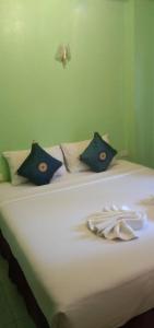 a white bed with blue pillows on it at Amorn Mansion in Ao Nang Beach