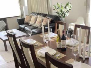 a dining room table with wine glasses and a couch at Second house TOYA / Vacation STAY 291 in Lake Toya