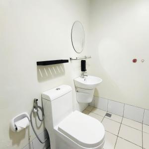 a white bathroom with a toilet and a mirror at eutz condominium daily rental in Cebu City