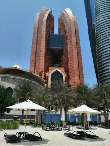 een groep tafels en parasols voor een gebouw bij Bab Al Qasr Hotel in Abu Dhabi