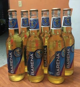 a group of six bottles of beer on a table at Tamarindo Hostel in San Pedro Sula