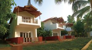 una fila de casas con árboles delante de ellos en Reva Resorts and Holiday Homes, en Chittoor