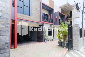 a facade of a building with a gate and plants at Dea Homestay Syariah Mitra RedDoorz At Kertomenanggal Surabaya in Siwalapkerto