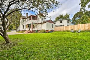 a yard with a fence in front of a house at Updated Vintage Apartment Less Than half Mi to Main St in Keene