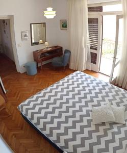 a bedroom with a large bed and a desk at Apartments Slavica - free WiFi in Vodice