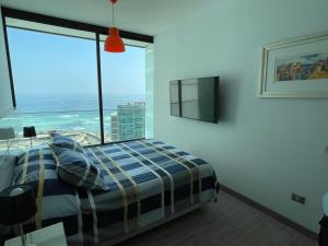a bedroom with a bed and a large window at Puerto Nuevo Antofagasta in Antofagasta