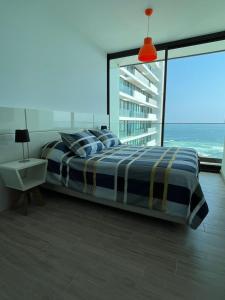 a bedroom with a bed with a view of the ocean at Puerto Nuevo Antofagasta in Antofagasta