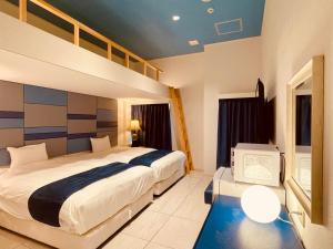 a bedroom with a bed and a tv in it at Phoenix Park Hotel in Nago