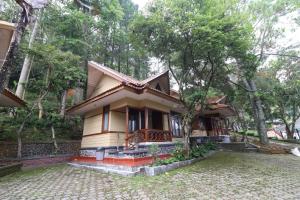 uma pequena casa no meio de uma floresta em Kampung Pa'go Resort Hotel em Bandung