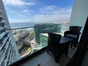 balcón con mesa, sillas y vistas al océano en Puerto Nuevo Antofagasta en Antofagasta