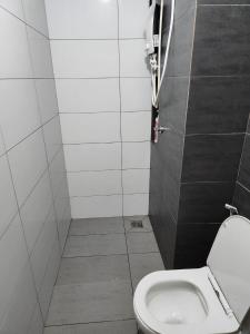 a small bathroom with a toilet in a stall at Aha Horizon Suites in Sepang