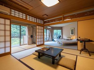 a japanese room with a bed and a table at Hakkei in Maniwa