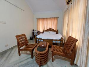 a room with a table and chairs and a bed at Casa Resort in Payyannūr