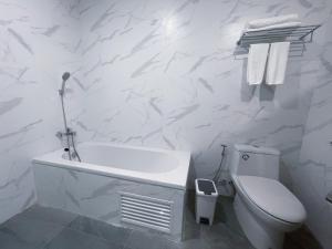 y baño blanco con aseo y bañera. en GRAND PA Hotel&Resort Lamphun Chiang Mai en Lamphun