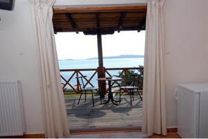 a room with a balcony with a view of the ocean at Porto Kalliali in Ouranoupoli