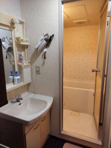 a bathroom with a sink and a shower at Lipelala Stay 505 in Osaka
