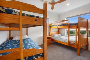 a bedroom with bunk beds in a house at Sandy Retreat - Waihi Beach Holiday Home in Waihi Beach