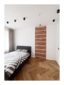 a bedroom with a bed and a brick wall at Garden appartament in a city center in Vilnius