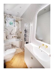 a white bathroom with a sink and a tub at Garden appartament in a city center in Vilnius