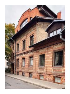 a red brick building with windows on a street at Garden appartament in a city center in Vilnius