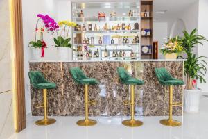 um bar com bancos verdes em frente a um balcão em Le Phan Hotel em Tây Ninh