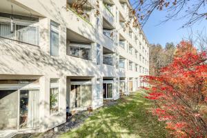 un edificio de apartamentos con árboles rojos delante de él en Village Gate Unit 209, en Warren