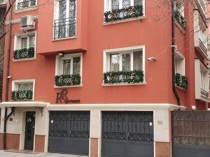 un bâtiment rouge avec des boîtes de fleurs sur les fenêtres dans l'établissement R & R Apartments, à Sofia