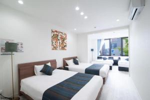 une chambre d'hôtel avec trois lits et un canapé dans l'établissement HIRO BUILDING Apartment Stay, à Fukuoka