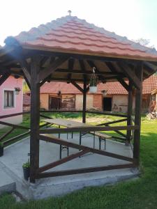 a wooden pavilion with a picnic table in a yard at Etno Kuca Badejevic in Plavna