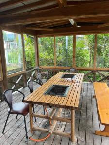 einen Holztisch und Stühle auf einer Holzterrasse in der Unterkunft 山水民宿 in Takayama