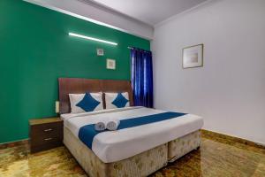a bedroom with a large bed with a green wall at Destino By INR Suites in Hyderabad