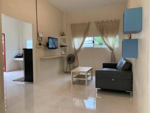 een woonkamer met een bank en een tafel bij W house Ranong 2bedroom villa 8/9 in Ranong