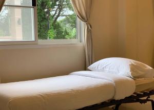 łóżko w pokoju z oknem w obiekcie W house Ranong 2bedroom villa 8/9 w mieście Ranong