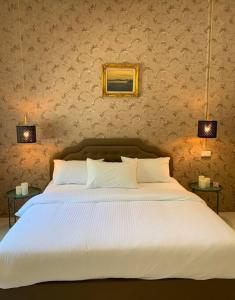 een slaapkamer met een groot wit bed met 2 lampen bij W house Ranong 2bedroom villa 8/9 in Ranong