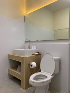 La salle de bains est pourvue de toilettes blanches et d'un lavabo. dans l'établissement W house Ranong 2bedroom villa 8/9, à Ranong