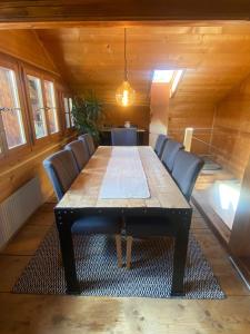 ein Esszimmer mit einem Holztisch und Stühlen in der Unterkunft Gstaad Paradise View Chalet with Jacuzzi in Rougemont