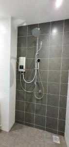 a shower with a hose on a tiled wall at Regalia Apartment B-3-1 Kota Samarahan in Kota Samarahan
