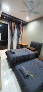 a bedroom with two beds and a ceiling fan at Regalia Apartment B-3-1 Kota Samarahan in Kota Samarahan