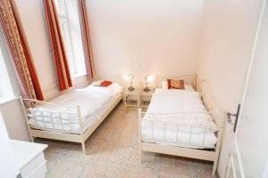 two beds in a room with two windows at Ferienwohnung 1 Holthusen 25514 in Weener